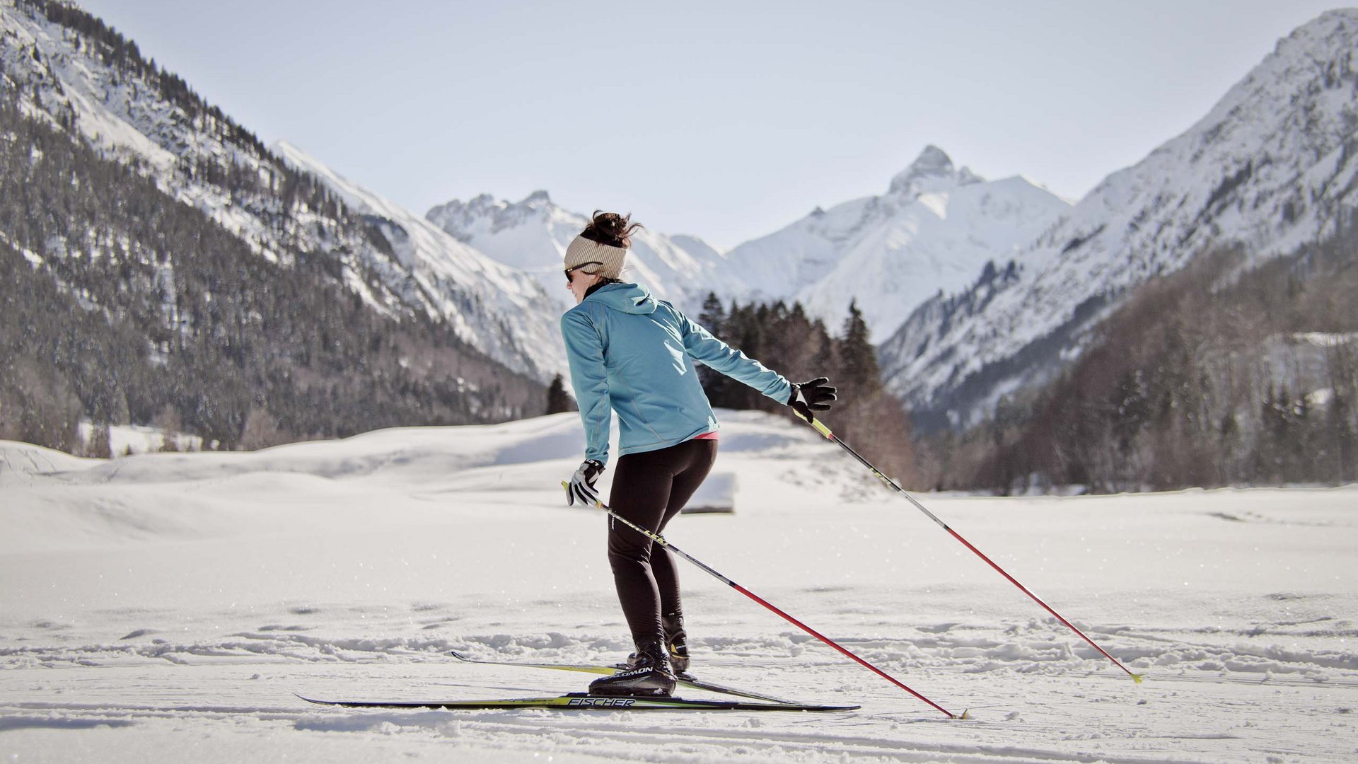 Plant euren Urlaub in Oberstdorf Frau beim Langlaufen in verschneiter Berglandschaft