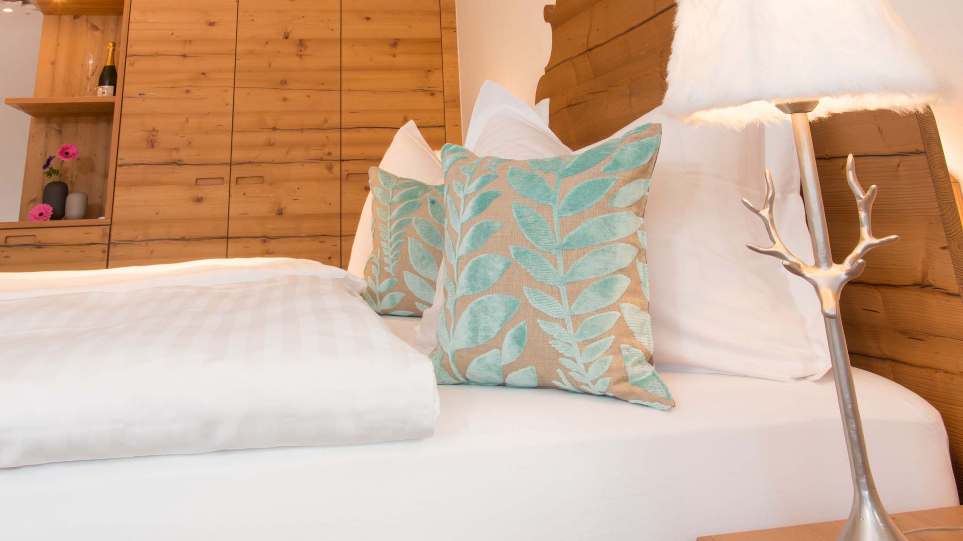 Hotel and holiday apartment in Allgäu, Oberstdorf Cozy bedroom with wooden wardrobe and decorative pillows