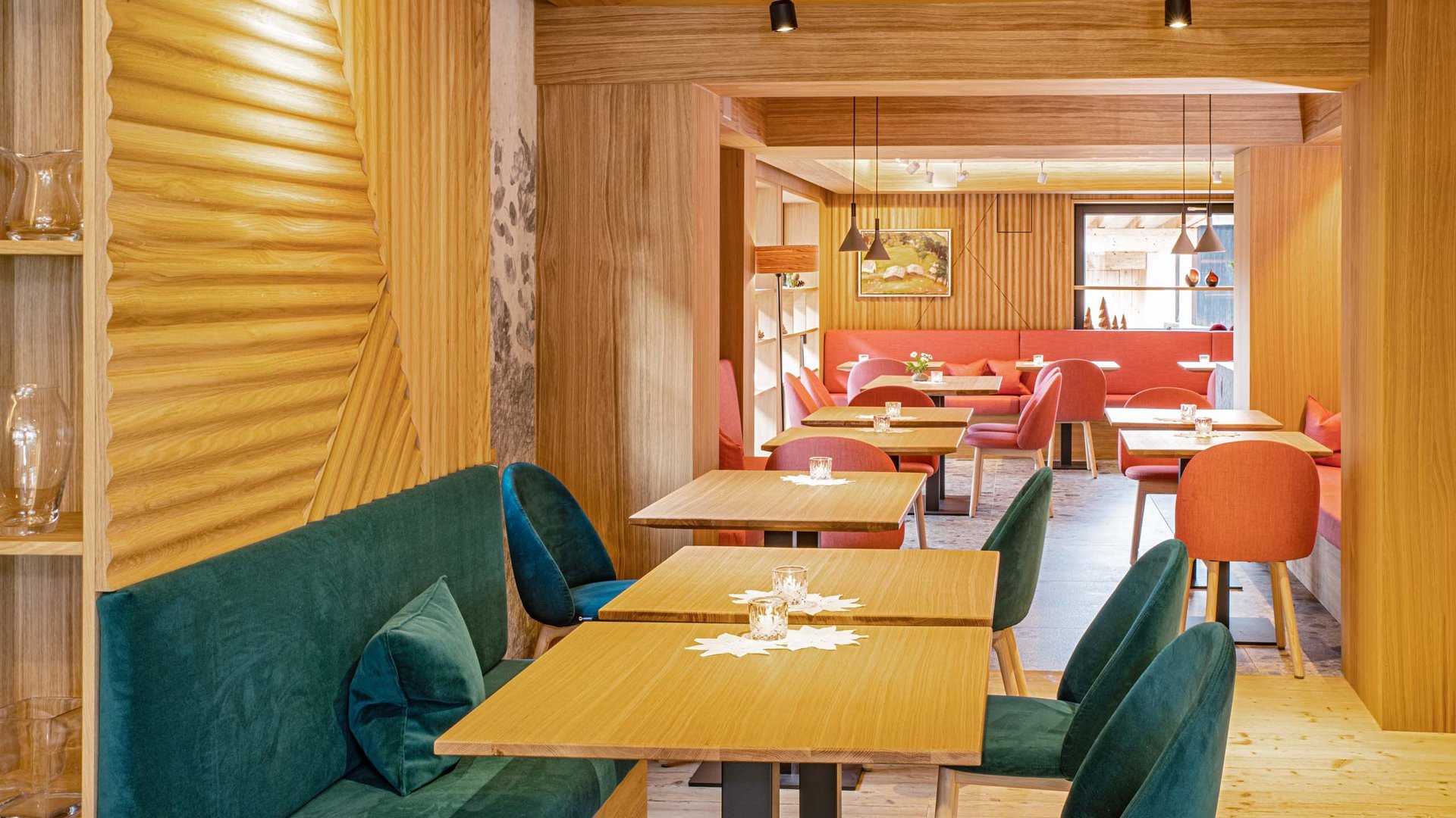 Hahnenköpfle: Ferienwohnung, Lodge und Hotel in Oberstdorf Moderne gemütliche Restaurantinneneinrichtung mit Holztischen und farbigen Stühlen