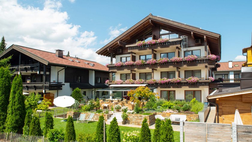 Hotel and holiday apartment in Allgäu, Oberstdorf Traditional chalet with flowers and terrace in sunny weather
