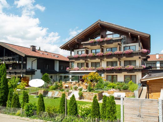 Hahnenköpfle: Ferienwohnung, Lodge und Hotel in Oberstdorf Traditionelles Chalet mit Blumen und Terrasse bei Sonnenschein