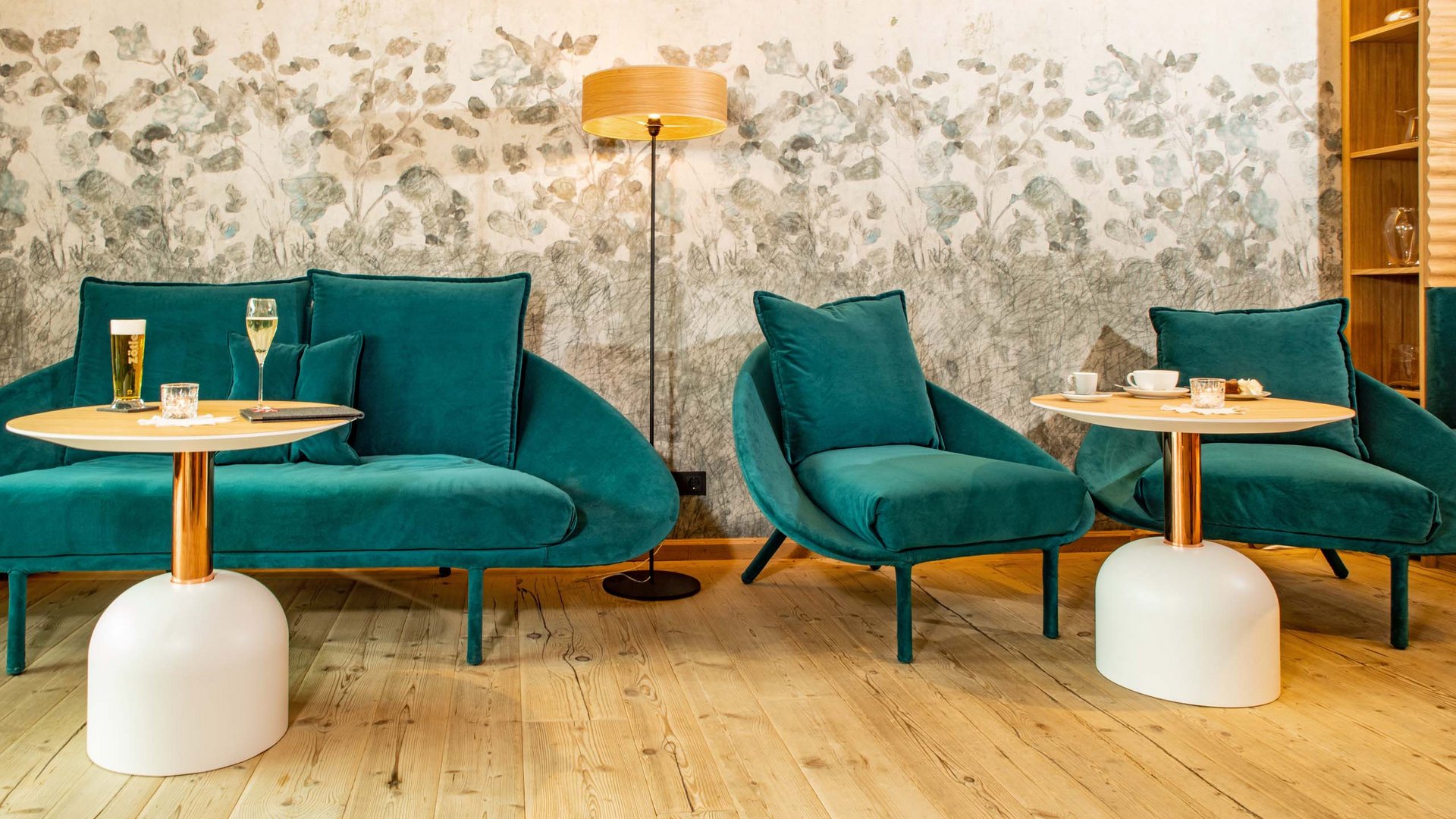 Euer Hotel in Oberstdorf mit Halbpension Gemütliche Sitzecke mit grünen Sesseln, Tischen und einer Stehlampe