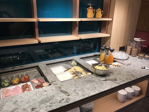 Euer Hotel in Oberstdorf mit Halbpension Buffet mit Aufschnitt, Käse, Säften und Cerealien auf grauer Theke