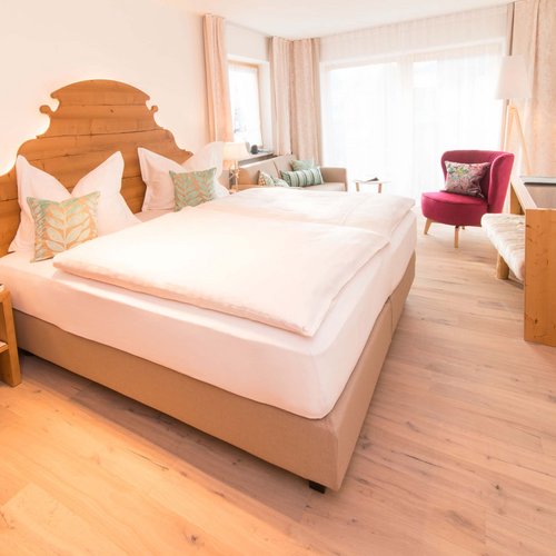 Hahnenköpfle: Ferienwohnung, Lodge und Hotel in Oberstdorf Gemütliches Hotelzimmer mit großem Bett und Sitzbereich